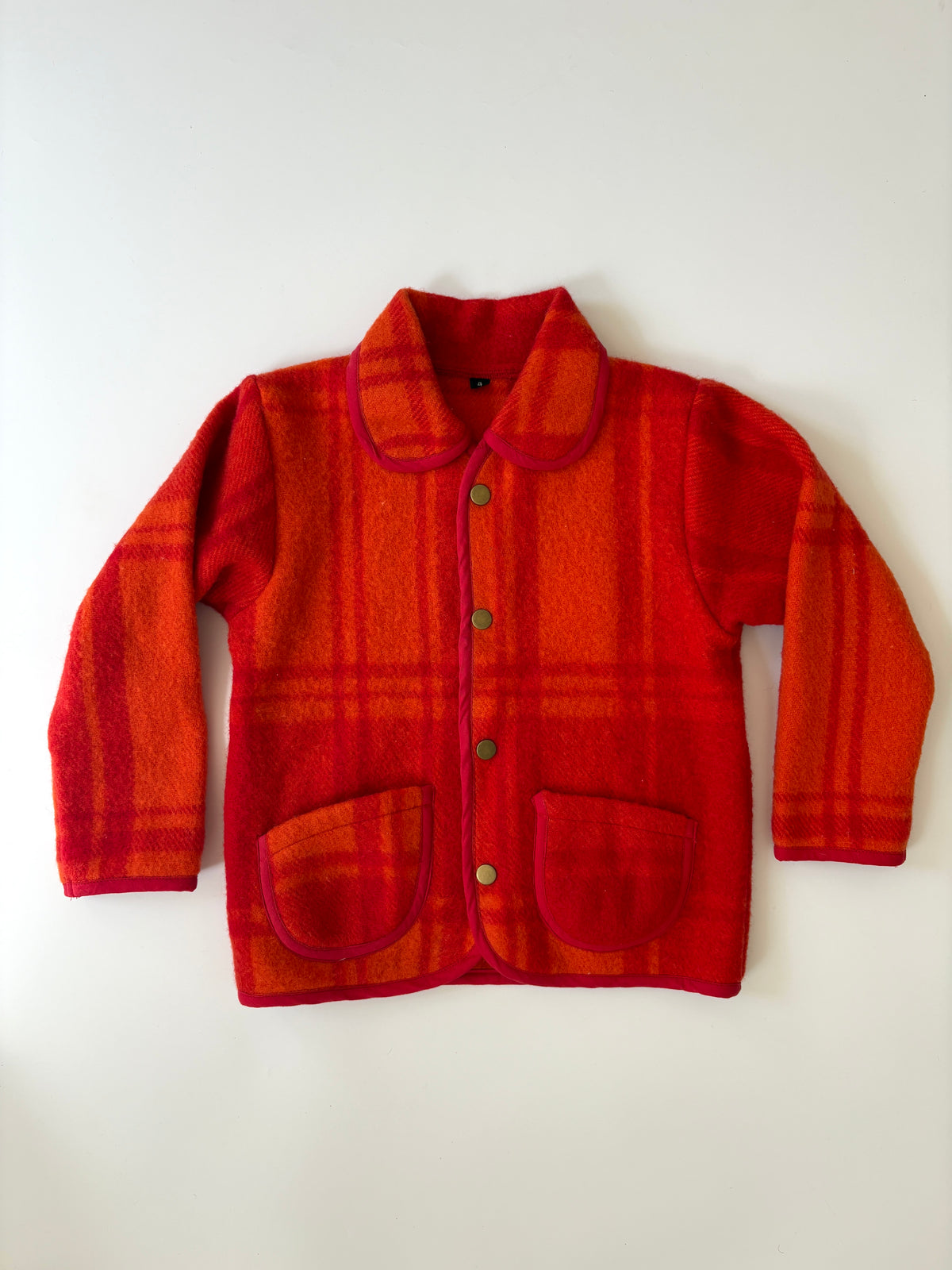 Red and orange plaid children's jacket. 
A red and orange plaid wool-blend jacket with a Peter Pan collar, button front, and two front patch pockets, laid flat against a light background.