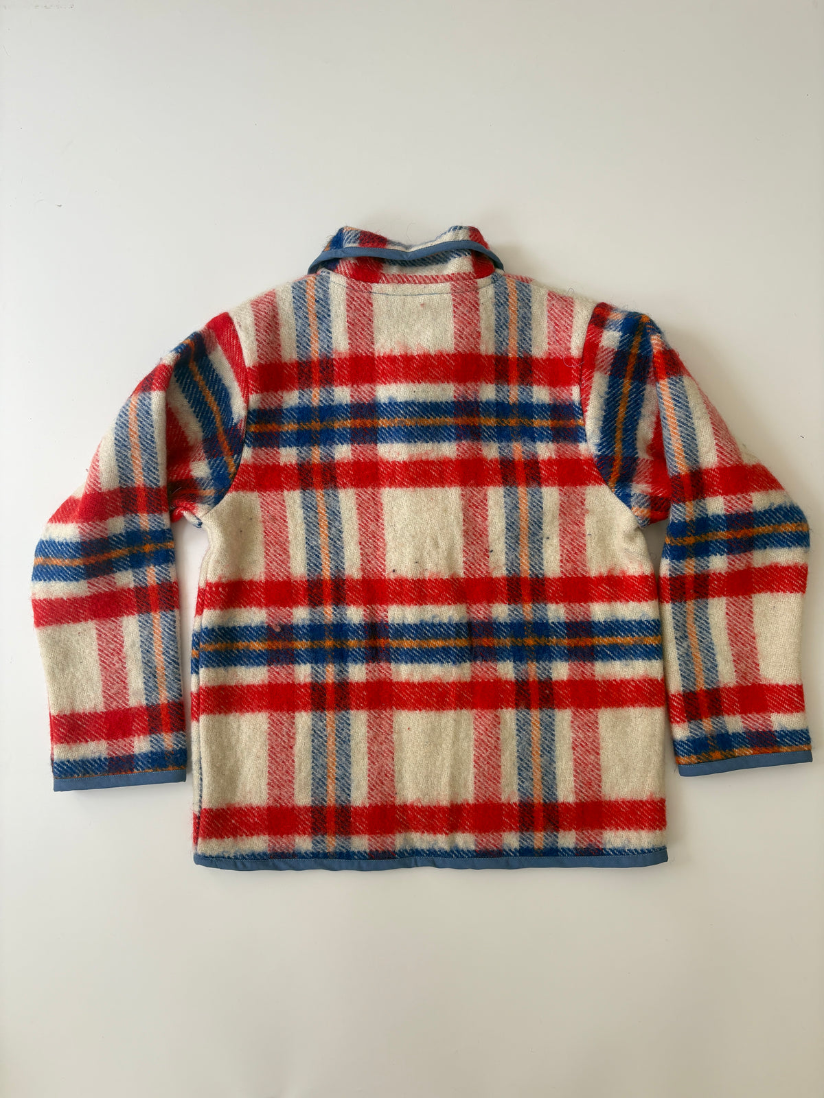 Red white & blue plaid blanket children's jacket. A vintage plaid wool jacket with red, blue, and cream stripes, featuring a button-up front and two front patch pockets, laid flat on a light background.